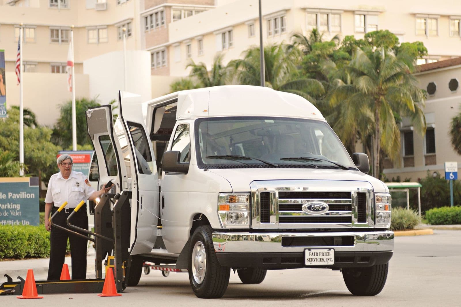 A driver preparing the lift on an accessible transport van outside a facility