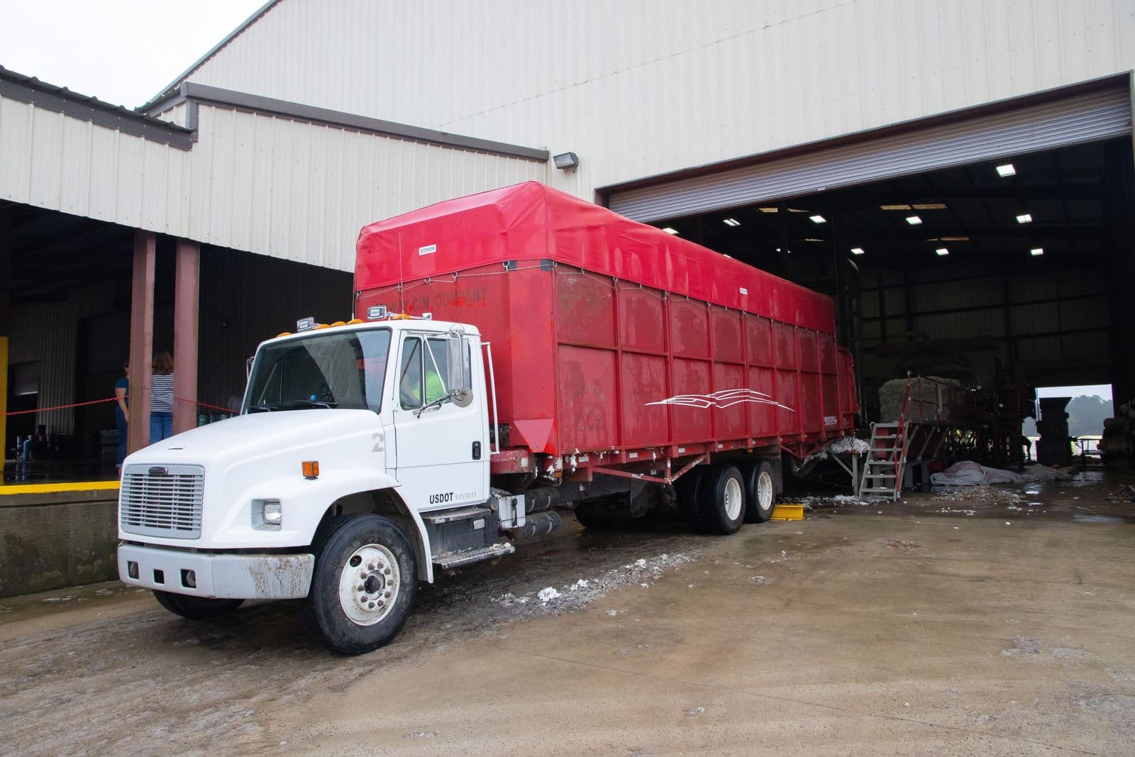 A tractor-trailer backed into a warehouse loading dock
